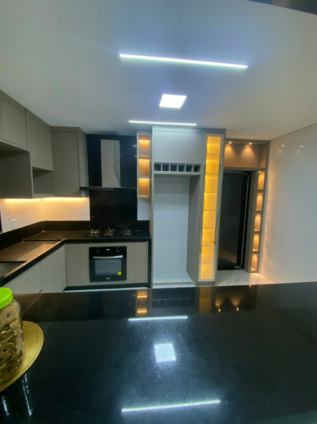 Cozinha planejada escura com nichos iluminados